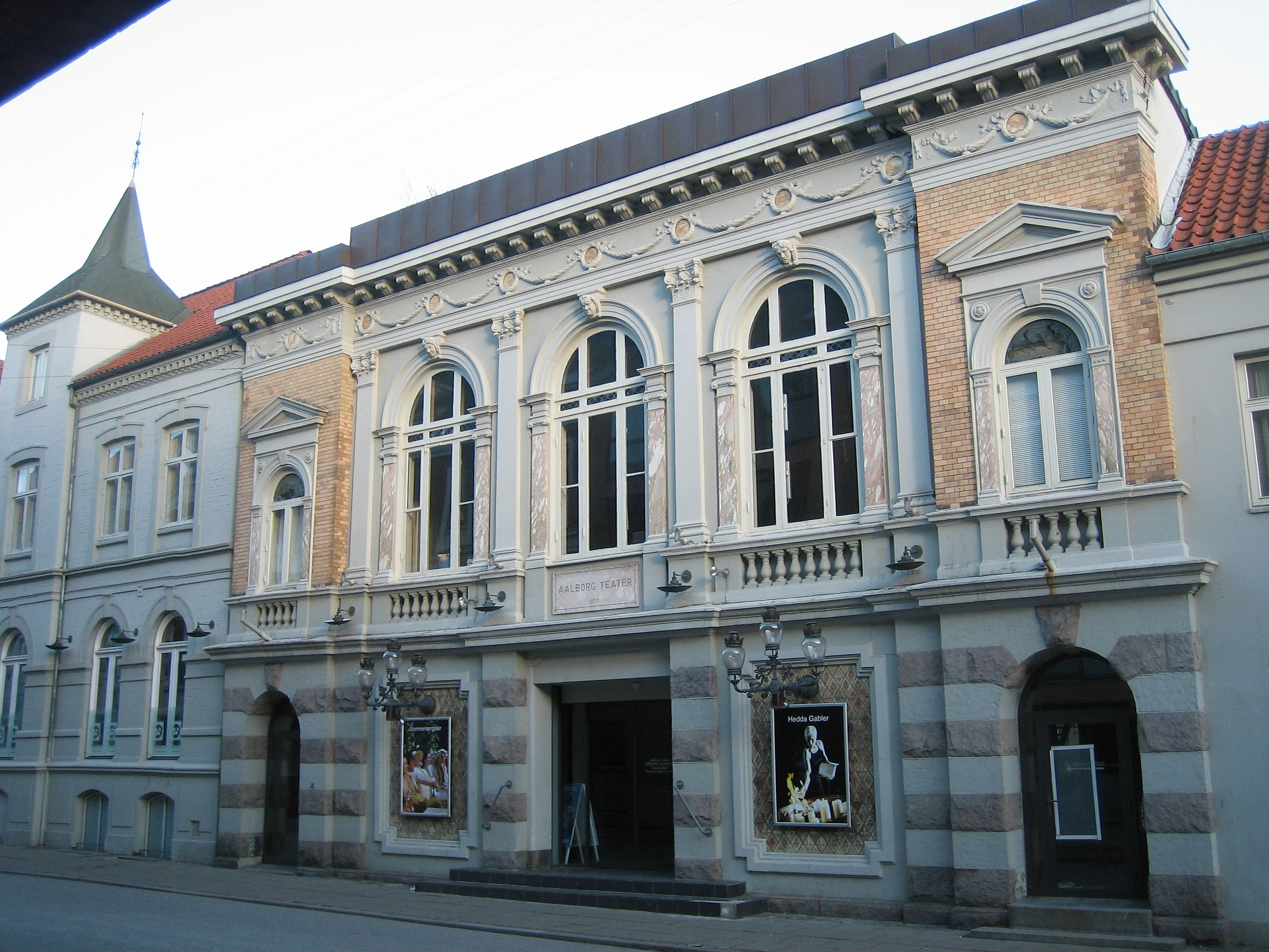 Gammel facade med høje vinduer og udsmykning i Aalborg