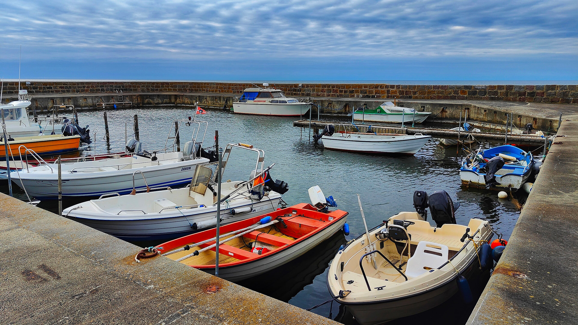 Små både i en havn på Bornholm en solskinsdag