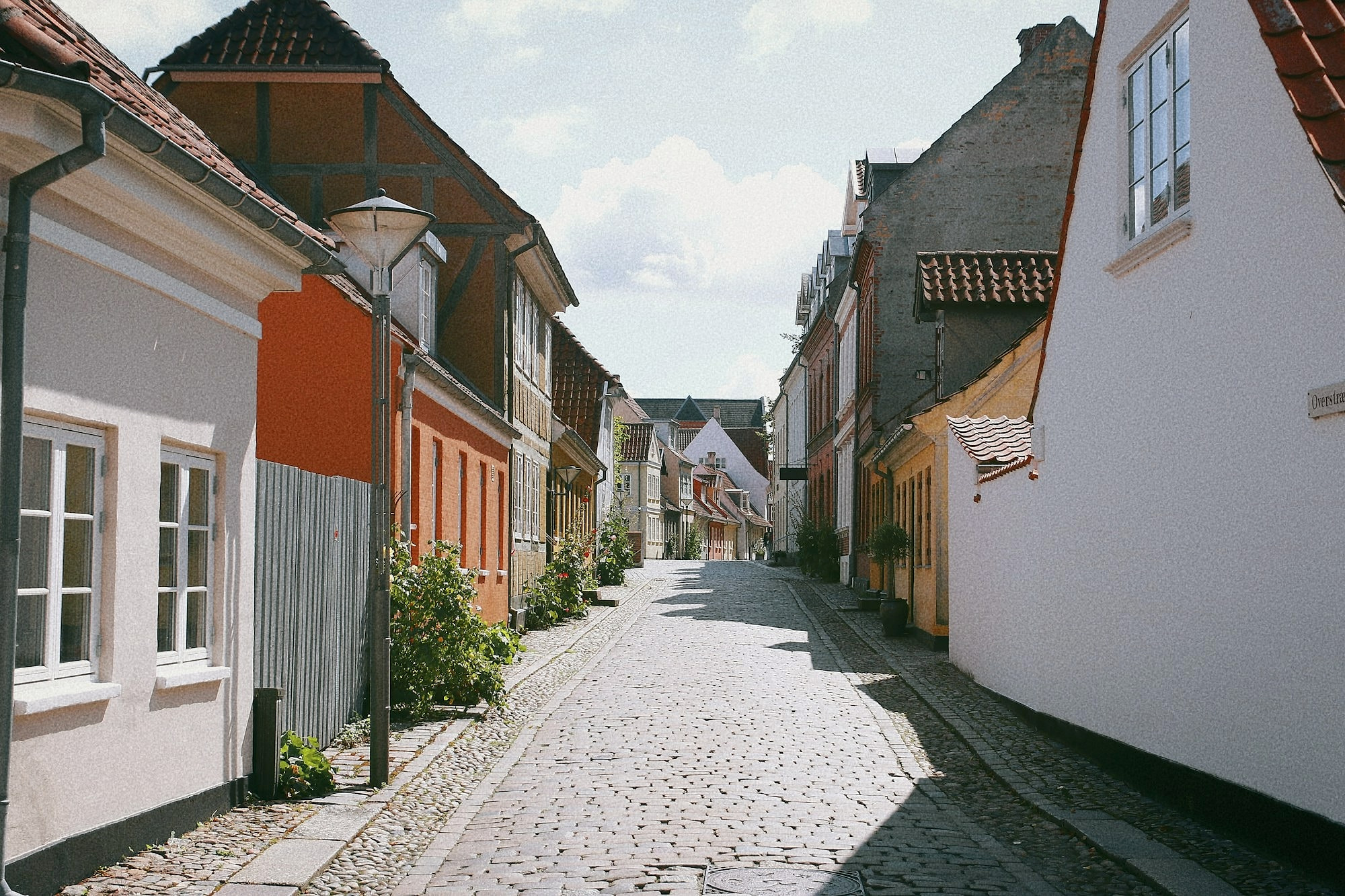 Smal brostensgade med gamle huse i Odense